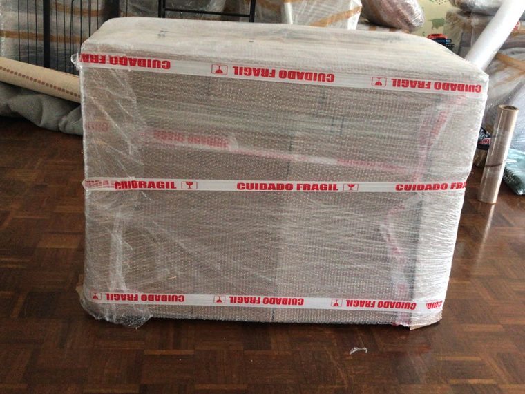 Móvel protegido com plástico bolha e fita de material frágil